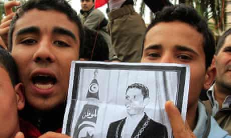 Tunisian protesters chant slogans as they hold a photograph of Mohamed Bouazizi