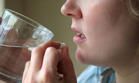 Woman taking pills with water