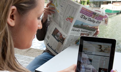 Woman and man reading Daily Telegraph in print and on an iPad