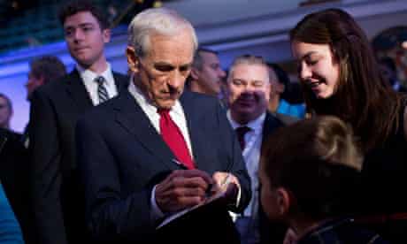 Ron Paul signs an autograph after a Republican presidential debate