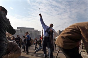 Clashes in Egypt day 9: A protester hurls a stone towards anti-Mubarak protesters in Tahrir Square
