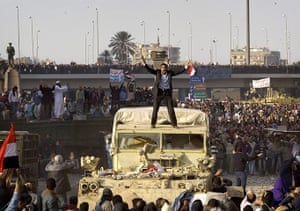 Egypt clashes day 9: A demonstrator stands on a military vehicle and tries to calm the crowd