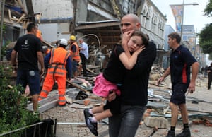 new zealand earthquake: A man holds a child in his arms after an earthquake in Christchurch
