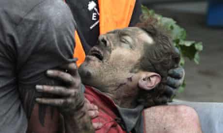 A man is seen after being pulled from the rubble after an earthquake in Christchurch