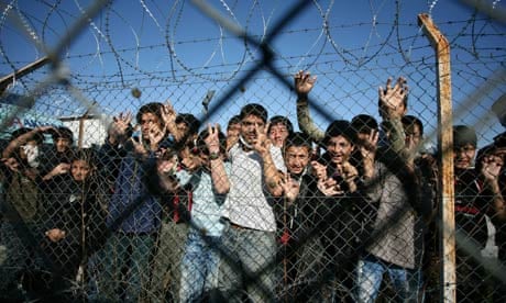 Children peer through the fence of an immigrant detention centre on the Greek-Turkish border