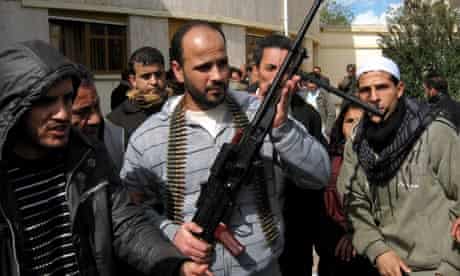 Libyan civilians display a machine gun they claim to have taken from mercenaries