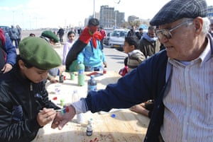 Benghazi celebrates: A young boy paints an elderly