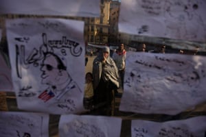 Egypt protests day 16: An Egyptian woman looks at anti-government slogans and caricatures