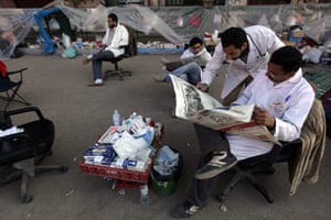 Egypt protests day 16: Anti-government doctors read the papers at a makeshift clinic