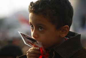 Egypt protests day 16: A young opposition supporter kisses an Egyptian flag 