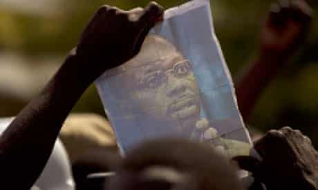 Jean-Bertrand Aristide's picture is held up by a demonstrator protesting against Rene Preval