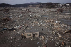 japan disaster aftermath: A rescue official walks through Minamisanriku 