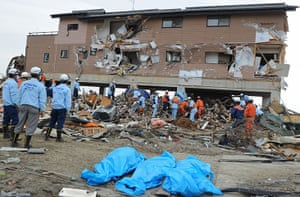 Japan tsunami rescue: The dead bodies of three people under blue plastic sheeting
