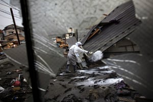 Japan tsunami rescue: An emergency worker throws disinfectant powder in Miyako, Iwate prefecture