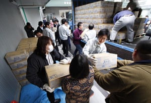 Japan Eartquake: Fukushima crisis : City workers move  bottles of water 