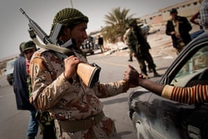Eastern Libya: A Libyan rebel greets a man on a checkpoint leading into Ras Lanuf,
