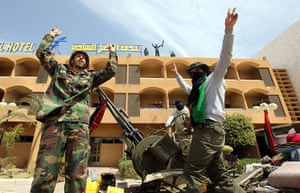 Eastern Libya: Libyan rebels flash the victory sign in front of a hote, Ras Lanuf