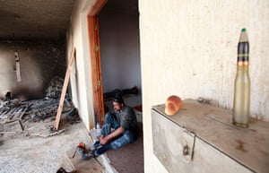 Eastern Libya: A rebel fighter puts his shoes on after praying, Ras Lanuf