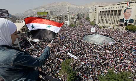 Syrian pro-government demonstrators gather in a central square in Damascus to support Assad 
