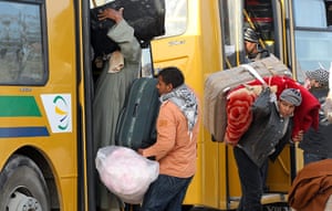 Refugees Flee Libya: Egyptians resident in Libya prepare to board a bus after fleeing the unrest
