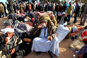 Refugees Flee Libya: Egyptian migrant workers drink tea while others line up for food 