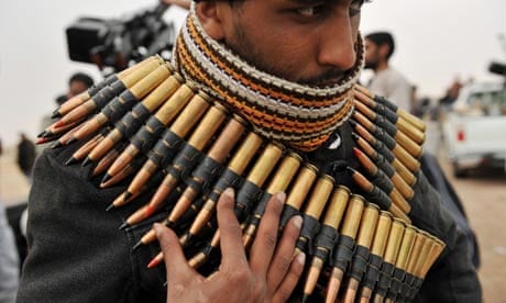 A Libyan rebel fighter wraps himself in a machine gun ammunition belt