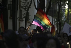 24 hours in pictures: Guadalajara, Mexico: Gay rights activists carry a flag during a march 