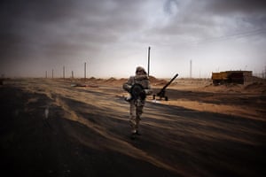 24 hours in pictures: Ras Lanuf, Libya: A Libyan rebel fighter mans a checkpoint