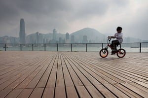 24 hours in pictures: Hong Kong, China: A boy rides his bicycle along the promenade