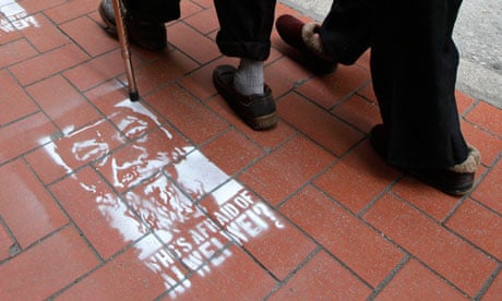 People in Hong Kong walk past street stencils of detained Chinese artist and activist Ai Weiwei