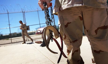 A guard holding leg shackles at Guantánamo Bay