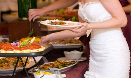 A bride getting food from a buffet at a wedding