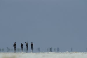 Disappearing world: Hunters from the San tribe cross a salt pan in the Kalahari.