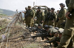 Israel violence: Israeli soldiers stand at the border fence between Israel and Syria 