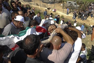 Israel violence: The body of a Syrian protester is carried near the border fence