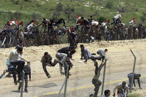 Israel violence: Syrian protesters climb the border fence between Syria and Israel