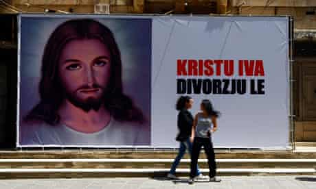 Young women walk past a billboard reading "Christ Yes, Divorce No" in Sliema