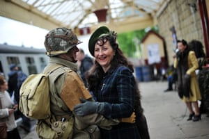 1940s re-enactment: A couple wait to board a steam train in Bury