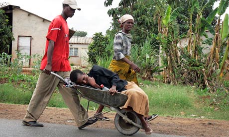 A woman with suspected cholera is taken in a wheelbarrow to a clinic in Harare