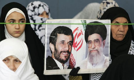 Iranian women hold portraits of Mahmoud Ahmadinejad and Ayatollah Ali Khamenei at Friday prayers