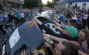 Vancouver riots: Vancouver Canucks fans push over a vehicle after their team's loss 