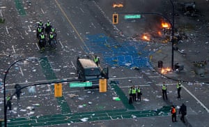 Vancouver riots: Police officers stand amongst debris after rioters moved through the area