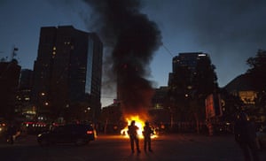 Vancouver riots: Police stand guard as police cars burn in the background 