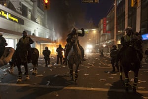 Vancouver riots: Police on horseback move down a street during a riot 
