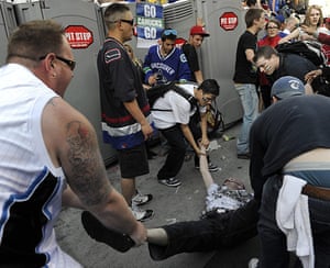 Vancouver riots: Canucks fans remove an unconscious man injured in a fight 