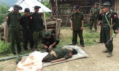 Kachin soldiers gather around the body of a comrade they claim died in fighting with Burmese troops