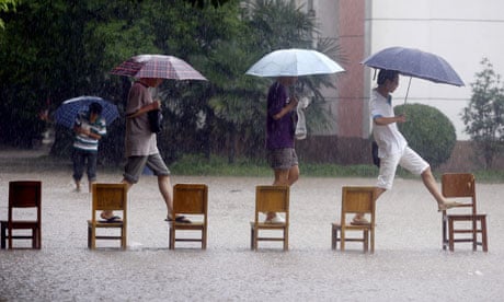 Students cross a flooded school yard in Wuhan