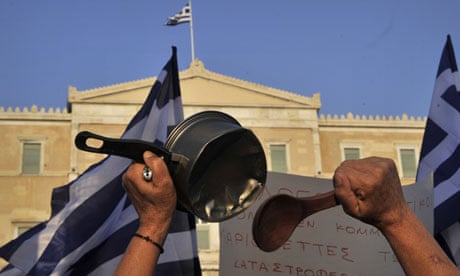 A greek protester beats a saucepan during a rally