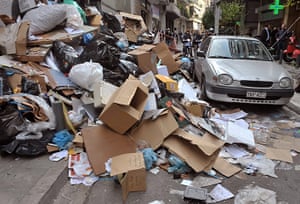Greece: 8 December: Credit rating downgraded. A car passes piles of garbage