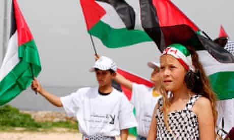 Children display Palestinian flags at a rally near Ramallah
